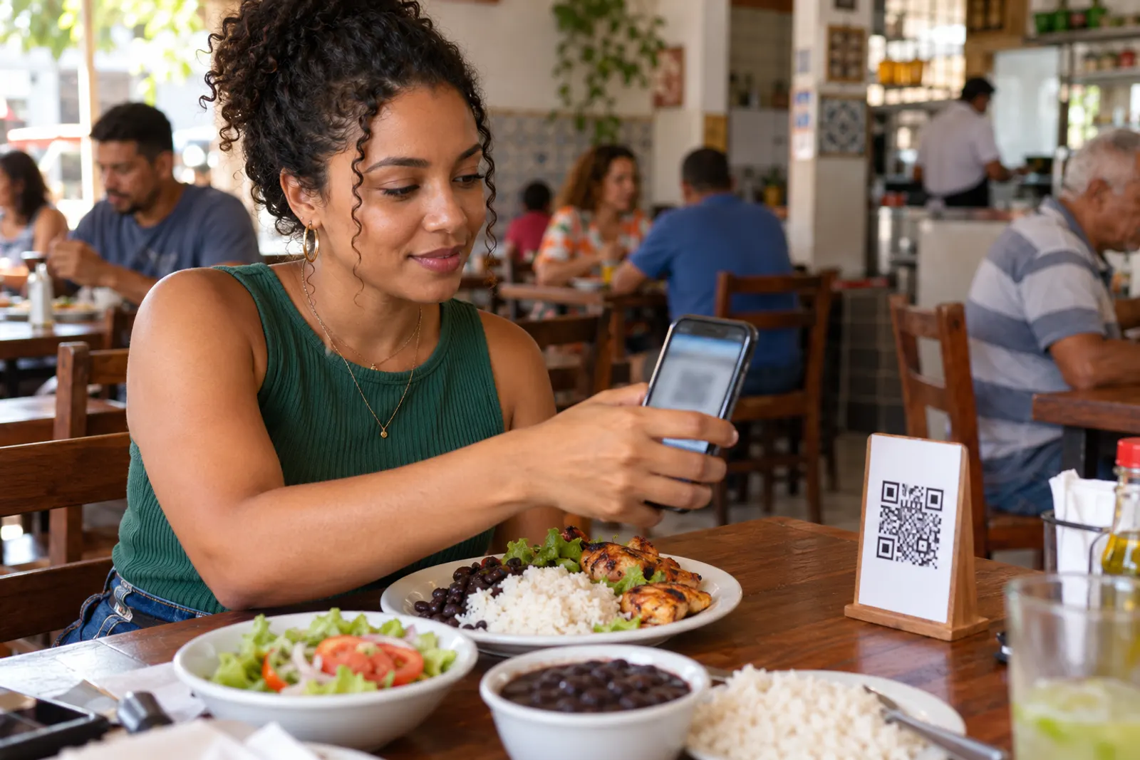 Cliente aponta o celular para o QR Code da mesa num restaurante movimentado
